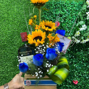 ARREGLO DE ROSAS Y GIRASOLES EN BASE CON FINA BOTELLA DE WHISKY